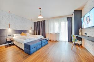a bedroom with a large bed and a blue couch at Apartamenty Sun & Snow Centrum - Plaża in Sopot