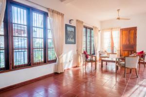 a living room with windows and a table and chairs at The Fields Malabe in Malabe