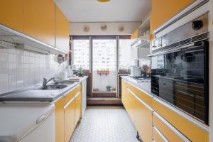 a kitchen with a sink and a large window at Veeve - Honeybee Haven in Paris