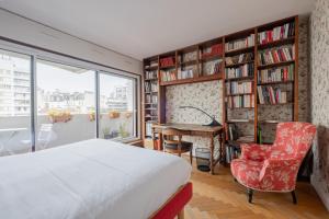 a bedroom with a bed and a desk and book shelves at Veeve - Honeybee Haven in Paris