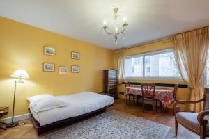 1 dormitorio con cama, mesa y ventana en Veeve - Honeybee Haven en París