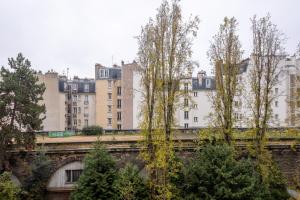 a bridge with trees and buildings in the background at Veeve - Honeybee Haven in Paris