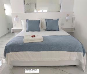 a bedroom with a large bed with blue pillows at Paternoster Penthouse - Solar in Paternoster