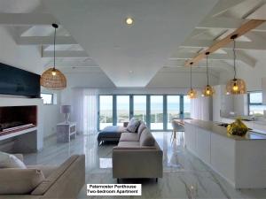 a large living room with a couch and a kitchen at Paternoster Penthouse - Solar in Paternoster