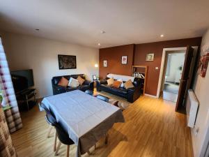 een woonkamer met een bank en een tafel bij Granite Getaways - Union Skyview in Aberdeen