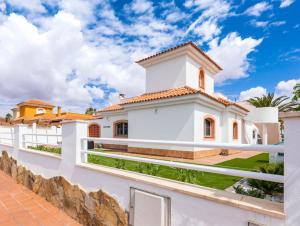 a white house with a fence and a wall at PRIMERA LUXURY HOUSE in Caleta De Fuste
