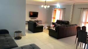 sala de estar con 2 sofás y TV en PNHouse Anguissa A2, en Yaoundé