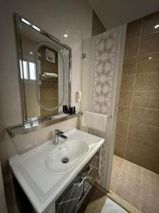 Sunrise Suites في تبوك: حمام مع حوض ومرآة