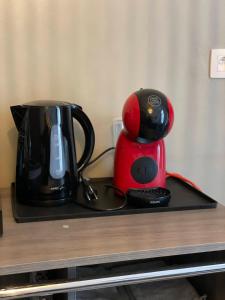 a red and black coffee maker sitting on a table at Chez Auguy et Deborah in Antwerp