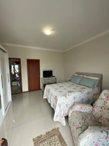 a bedroom with a bed and a couch at Apartamento Cobertura Ingleses Gr in Florianópolis