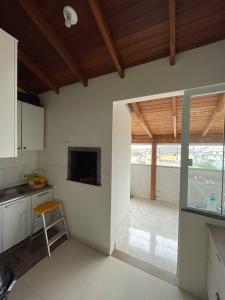 cocina con mesa y silla en una habitación en Apartamento Cobertura Ingleses Gr, en Florianópolis