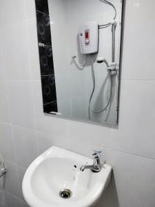 a bathroom with a sink and a mirror at The Big Family Homestay in Alor Setar