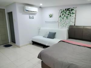 a room with a bed and a couch in it at The Big Family Homestay in Alor Setar