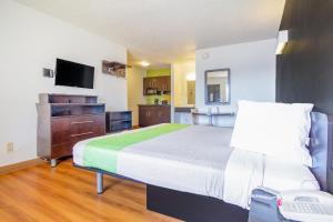 a large bedroom with a bed and a television at Studio Inn Extended Stay Oklahoma City Airport by OYO in Oklahoma City