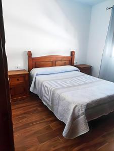 ein Schlafzimmer mit einem Bett und zwei Nachttischen in der Unterkunft Casa con Terraza y Barbacoa en el Casco Antiguo in Barbate