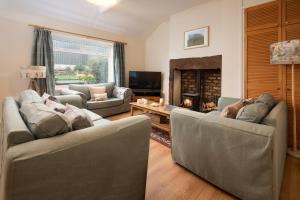 a living room with two couches and a fireplace at Thornton Farm Cottages in Berwick-Upon-Tweed