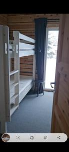 a room with two bunk beds and a window at Ammeråns Fiskecamp in Hammarstrand