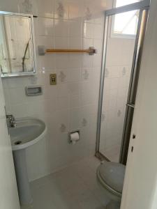 a bathroom with a sink and a toilet and a shower at Apartamento Praia do Morro - Guarapari in Guarapari