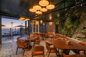 a restaurant with tables and chairs and a view of the ocean at Zostel Mussoorie (Mall Road) in Mussoorie