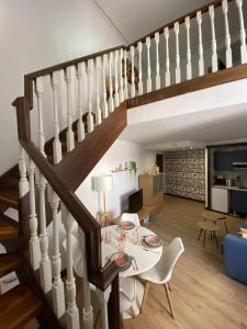 a living room with a table and a staircase at Edificio El Moderno Puerta del Sol in Vigo