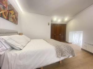 Schlafzimmer mit einem großen weißen Bett in der Unterkunft Edificio El Moderno Puerta del Sol in Vigo