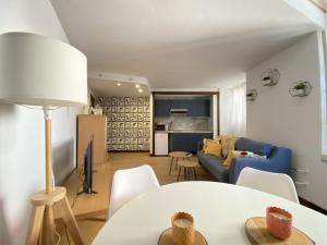 ein Wohnzimmer mit einem Sofa und einem Tisch in der Unterkunft Edificio El Moderno Puerta del Sol in Vigo