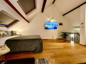 a bedroom with a bed and a tv on the wall at Luxury Suites Museum by Rikas Hotels in Antwerp