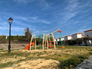 a playground with a slide in a park at Ronko House El Ronquillo in El Ronquillo