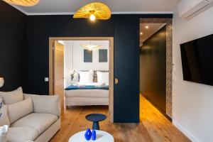 uma sala de estar com um sofá e uma cama em The Blue Suite Downtown Montmartre em Paris