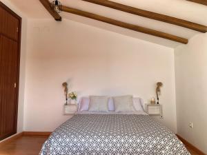 a bedroom with a bed in a white wall at Ronko House El Ronquillo in El Ronquillo