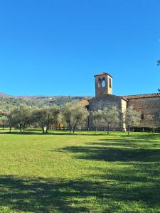 ein altes Gebäude mit einem Turm auf einem Feld in der Unterkunft Il Melograno in Toscana in Castelfranco di Sopra