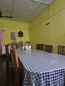 uma sala de jantar com uma mesa de xadrez azul e branco em Shivaji Inn Kaziranga em Kaziranga