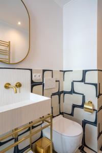 パリにあるThe Blue Suite Downtown Montmartreのバスルーム(白いトイレ、鏡付)