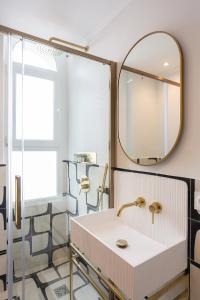 uma casa de banho com um lavatório e um espelho em The Blue Suite Downtown Montmartre em Paris
