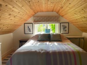 Schlafzimmer mit einem großen Bett und einem Fenster in der Unterkunft Little Barn in Dorchester