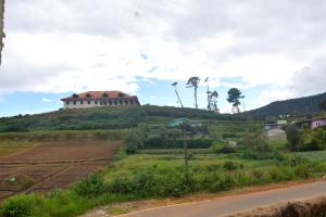 a house on top of a hill next to a road at The Dew Drop Villa in Nuwara Eliya
