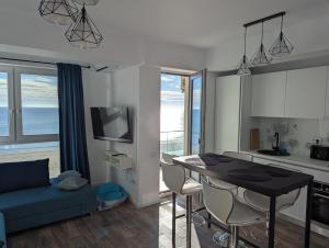 a kitchen and a living room with a table and chairs at Black Sea Overlook in Mamaia Sat/Năvodari