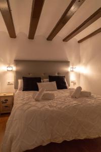 um quarto com uma grande cama branca e 2 almofadas em Gadita Suite by Gades Gestión em Cádiz