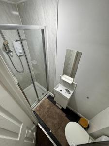 uma casa de banho com um chuveiro, um WC e um lavatório. em Seven Stars of Heeley Selly Oak em Birmingham