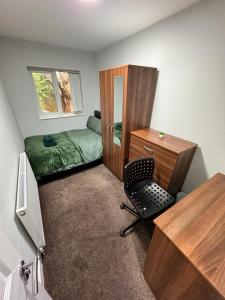 a bedroom with a desk and a bed and a chair at Seven Stars of Heeley Selly Oak in Birmingham
