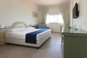Dormitorio con cama, escritorio y TV en Summit Hotel, en Gaeta
