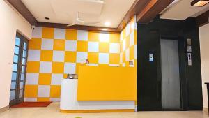 um átrio com uma parede xadrez amarela e branca em Athasri Hotel HSR Layout em Bangalore