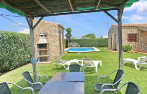 a patio with chairs and a table and a swimming pool at Chalet Piedra in Conil de la Frontera