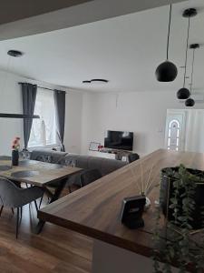 uma sala de estar com uma mesa de madeira e cadeiras em Villa Anna, ingyenes Wifivel és parkolással. em Zalaegerszeg