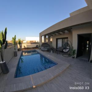 une maison avec une piscine sur une terrasse dans l'établissement וילת צאלים, à Yeruham