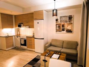 ein Wohnzimmer mit einem Sofa und einer Küche in der Unterkunft Pro Apartments 3 in Vaasa