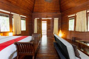 een slaapkamer met een bed en stoelen in een kamer bij RedDoorz Resort @ Taman Wisata Mangrove in Jakarta