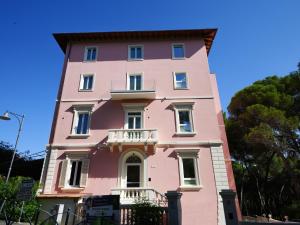 a pink building with a balcony on top of it at Castiglioncello Suite in Castiglioncello