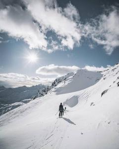 een persoon is aan het skiën in een met sneeuw bedekte berg bij Luksushytte med Jacuzzi, Summer&Winter Retreat in Lyngværet