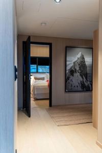a bedroom with a bed and a picture of a mountain at Luksushytte med Jacuzzi, Summer&Winter Retreat in Lyngværet